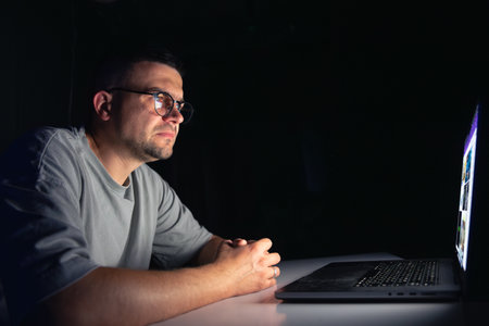 Young man works at the computer at night.の写真素材