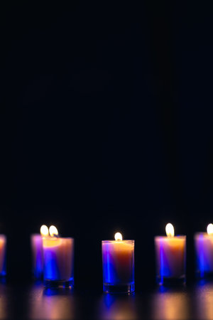 Burning candle on black background with backlight. Memorial Day.の写真素材