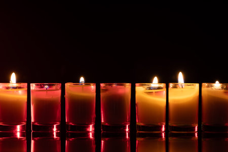 Burning candle on black background with backlight. Memorial Day.の写真素材