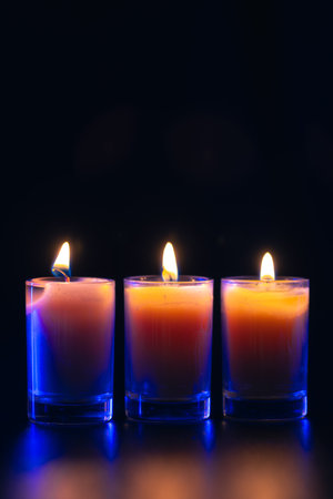 Burning candle on black background with backlight. Memorial Day.の写真素材