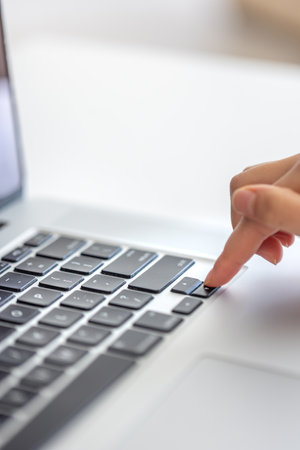 The girl is typing on the laptop keyboard. Girls hands on the keyboard.の写真素材