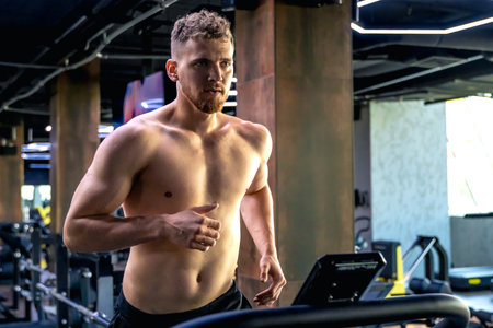 Athlete on a treadmill in the gym. Shirtless man in the gym. Sports lifestyle.の写真素材