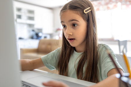 A schoolgirl studies online at home. School education online.の写真素材