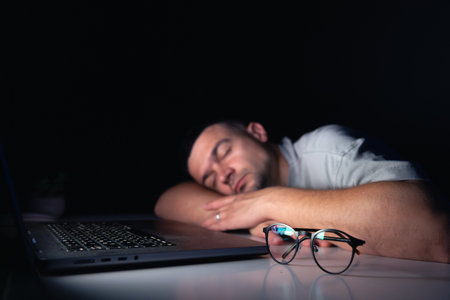 Young man works at the computer at night.の写真素材
