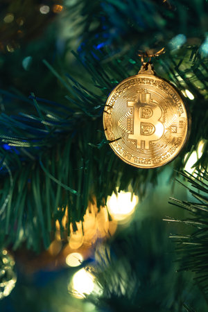 Bitcoin coin on christmas tree with bokeh lights. Finance concept.の写真素材