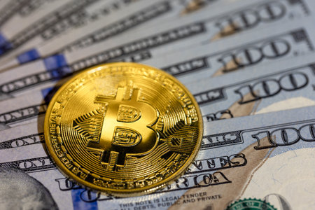Bitcoin coin with 100 dollar bill. Concept of finance background close-up.の写真素材