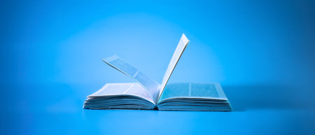 An open book on a blue background. Education background. Back to school.の写真素材