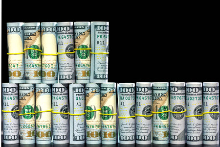 Twisted 100 dollar bills on a black background. Finance concept background.の写真素材