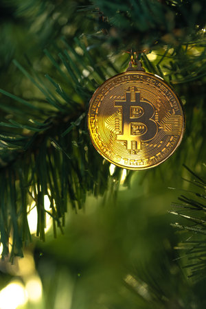 Bitcoin coin on christmas tree with bokeh lights. Finance concept.の写真素材