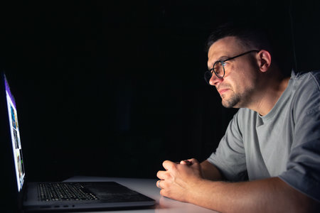 Young man works at the computer at night.の写真素材
