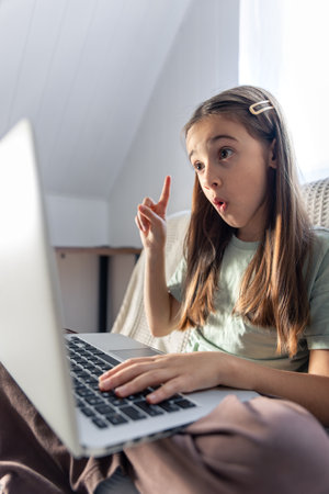 A schoolgirl studies online at home. School education online.の写真素材
