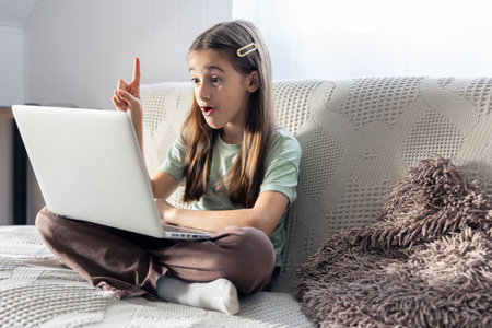 A schoolgirl studies online at home. School education online.の写真素材