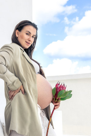 Pregnant woman with protea flowers. Concept of style and pregnancy.