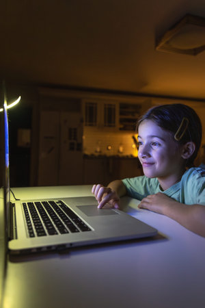 Beautiful girl studies at the computer at night. Technology and education.