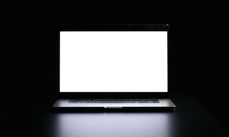 Modern laptop with blank white screen isolated on black background. Close up.の写真素材