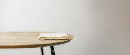 A book on a wooden table. A book and a table on a light background.
