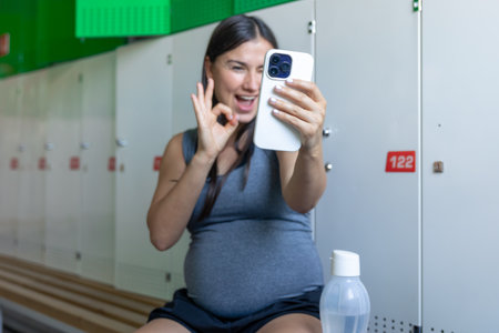 Sports pregnant woman makes selfies after workout at the gym.の写真素材