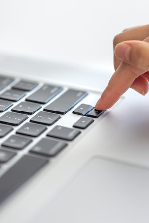 The girl is typing on the laptop keyboard. Girls hands on the keyboard.の写真素材