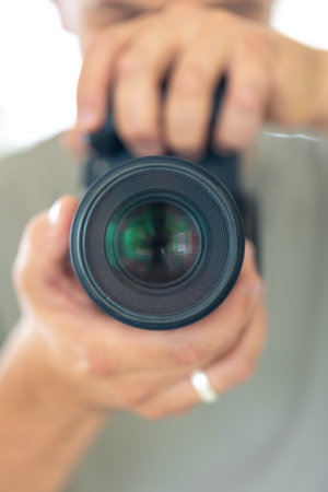A man takes a photo of himself in the mirror with a camera. Close-up photo.の写真素材