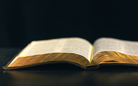 Open Bible on a black background. Religion concept.の写真素材