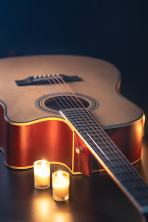 Acoustic guitar on a black background with candles.の写真素材