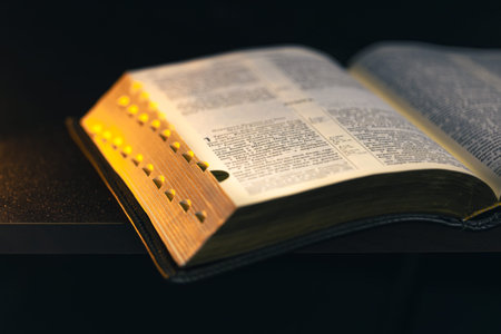 Open Bible on a black background. Religion concept.