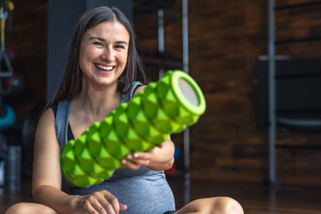 Pregnant woman with massage roller in the gym. Active healthy lifestyle.の写真素材