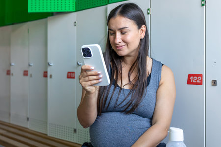 Sports pregnant woman makes selfies after workout at the gym.