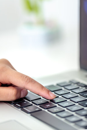 The girl is typing on the laptop keyboard. Girls hands on the keyboard.の写真素材