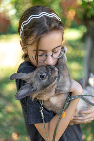A girl plays with a domestic rabbit on the street. Pet concept.の写真素材