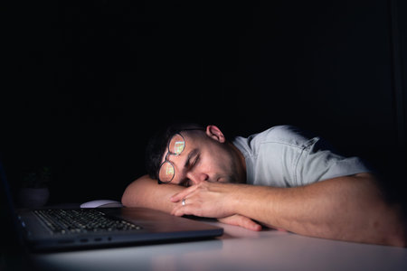 Young man at the computer at night.