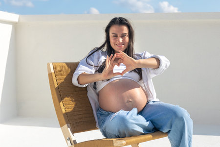 Joyful pregnant woman on the background of the sky. Concept of pregnancy.