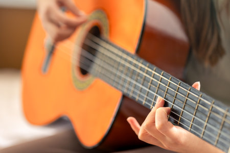 The girl plays the classical or acoustic guitar. Guitar close-up.の写真素材