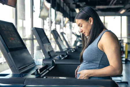 Pregnant woman on a treadmill in the gym. Healthy sports lifestyle.の写真素材