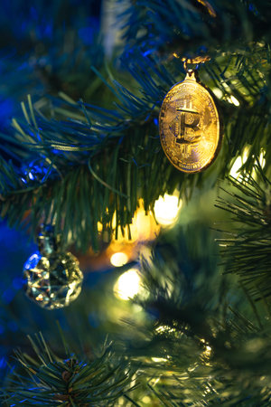 Bitcoin coin on christmas tree with bokeh lights. Finance concept.