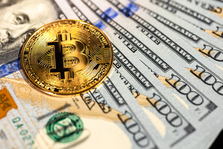Bitcoin coin with 100 dollar bill. Concept of finance background close-up.の写真素材