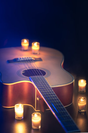 Acoustic guitar on a black background with candles.の写真素材