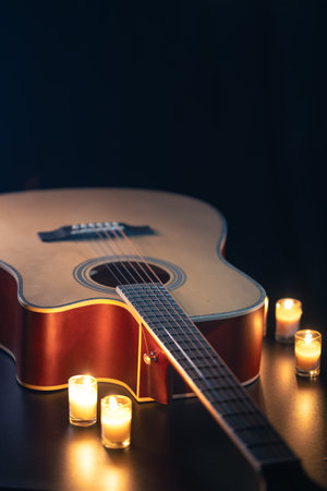 Acoustic guitar on a black background with candles.の写真素材