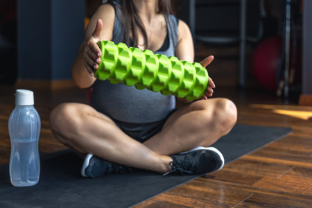 Pregnant woman with massage roller in the gym. Active healthy lifestyle.の写真素材