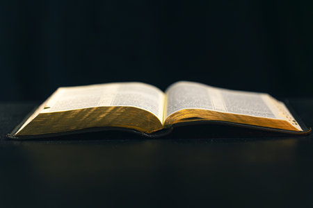 Open Bible on a black background. Religion concept.の写真素材