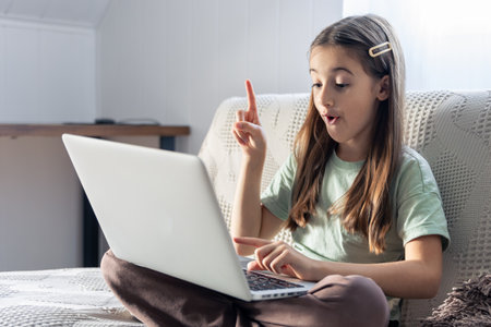 A schoolgirl studies online at home. School education online.の写真素材