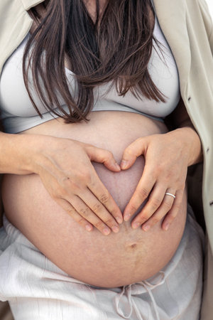 Pregnant woman with a heart on her stomach. Pregnancy concept.