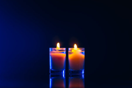 Burning candle on black background with backlight. Memorial Day.の写真素材