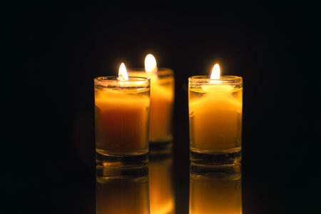 Burning candle on black background with backlight. Memorial Day.の写真素材