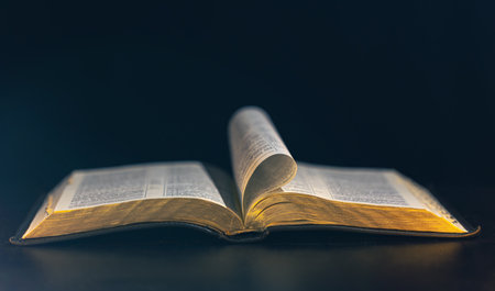 Open Bible on a black background. Religion concept.の写真素材