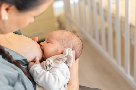 A mother breastfeeds a newborn baby. Motherhood child care concept.