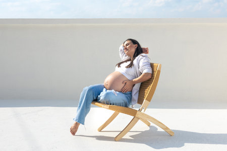 Joyful pregnant woman on the background of the sky. Concept of pregnancy.の写真素材