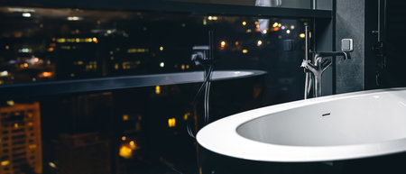 Stylish minimalist bathroom. White bath on a dark background.の写真素材