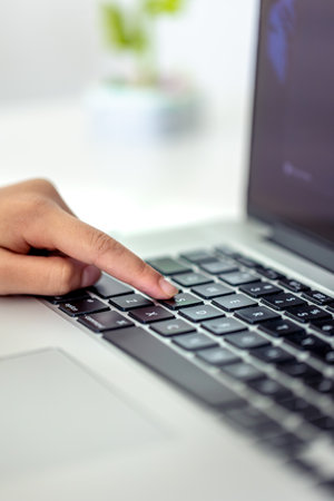 The girl is typing on the laptop keyboard. Girls hands on the keyboard.の写真素材