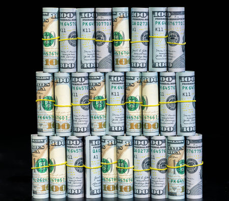 Twisted 100 dollar bills on a black background. Finance concept background.